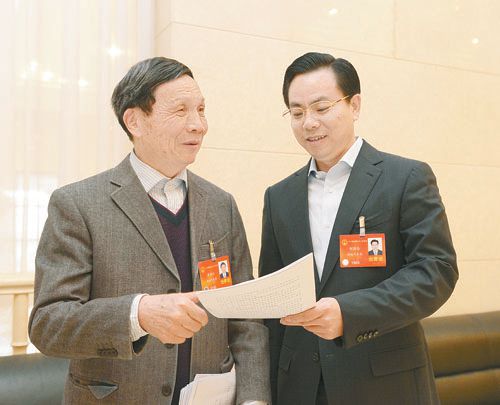 黃伯云代表（左）與劉國(guó)忠代表商討完善《關(guān)于建立戰(zhàn)略性新興產(chǎn)業(yè)國(guó)家創(chuàng)新平臺(tái)》的建議。 本報(bào)記者 張目 攝